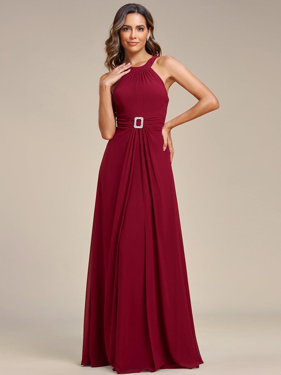 Robe longue en mousseline à col licou et taille avec diamants brillants #Couleur_Bordeaux Robe longue en mousseline à col licou et taille avec diamants brillants